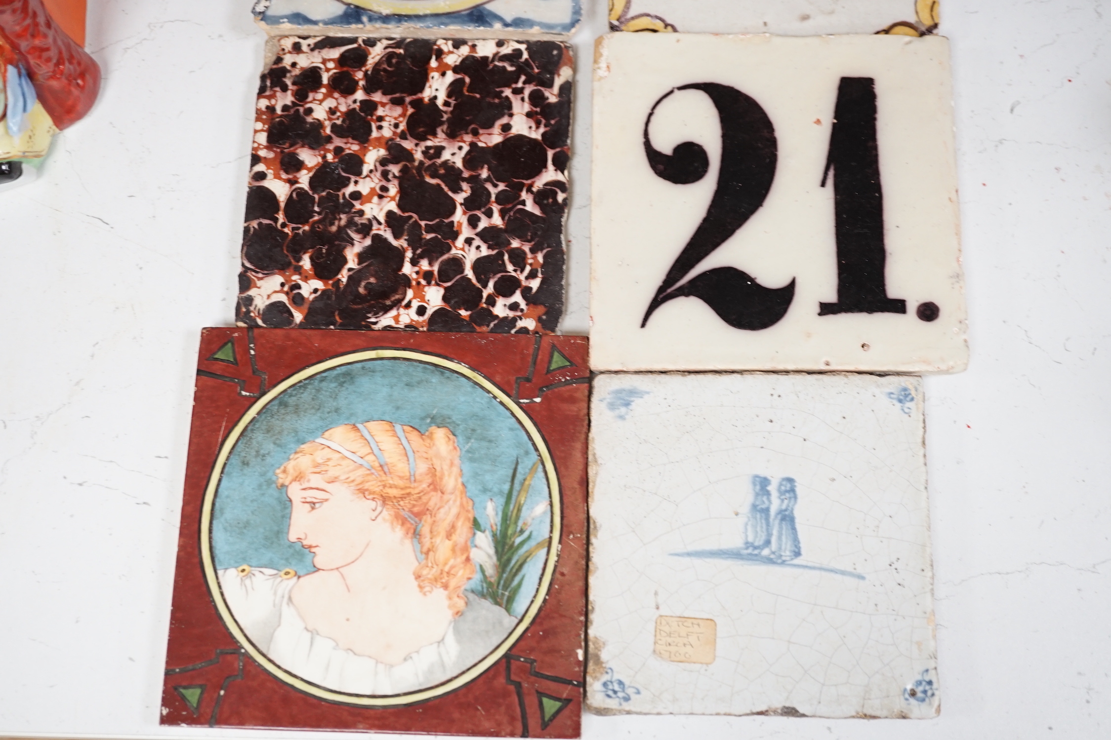 A collection of Continental tiles including 17th & 18th century Delft, Pre-Raphaelite style and two lustre fish examples, largest 15 x 15cm (9)